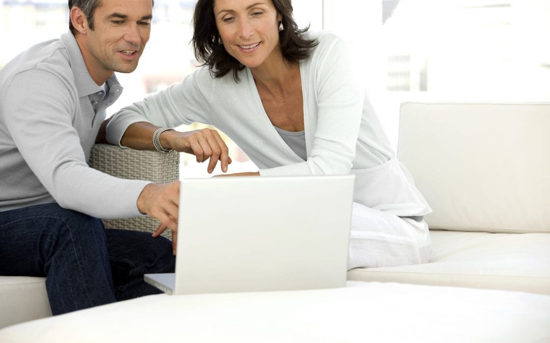 Middle-aged couple using laptop | Clarity Hearing