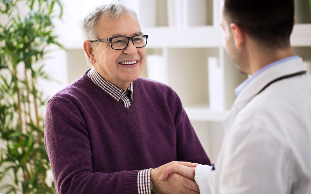 Smiling happy healthy old male shaking with doctor | Clarity Hearing