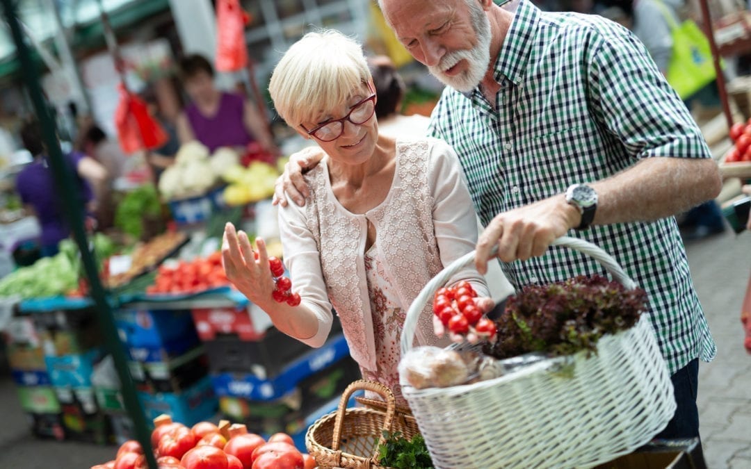 Senior shopping couple with basket on the market. Healthy diet. | Clarity Hearing